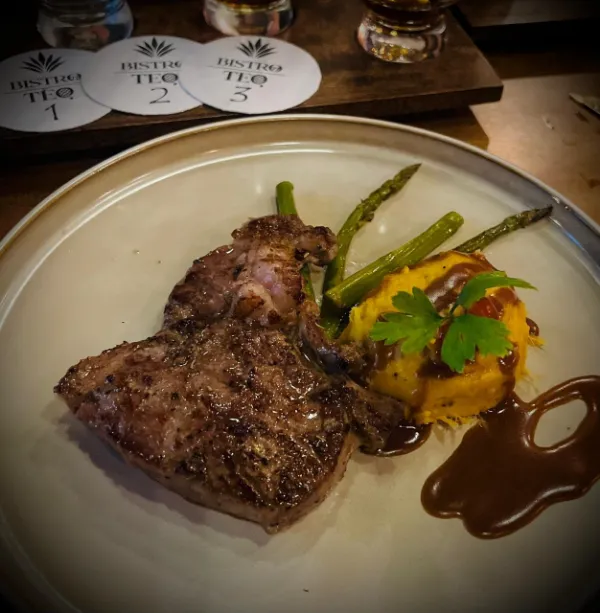 Corte a la parrilla con espárragos y puré, junto a los posavasos numerados de Bistroteq