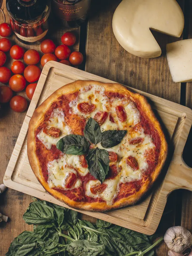 Pizza margarita sobre tabla de madera, vista desde arriba